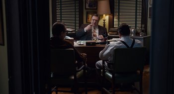 Movie still from “Trumbo” (2015), directed by Jay Roach – A group of men sitting at a table in a room; Medium shot, High angle