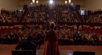 Movie still from “Trumbo” (2015), directed by Jay Roach – An audience is watching a woman in an old - fashioned dress; Extreme Wide shot, High angle