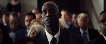 A man wearing a suit and tie in front of a group of people