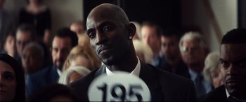 A man in a suit and tie with a number on his chest