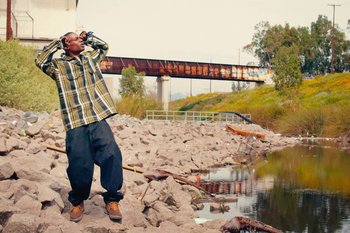 Movie still from “Huey Briss & Nikobeats - Grace Park Legend” (2021), directed by Michael Priestley – Medium shot, Low angle