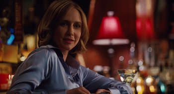 Movie still from “Up in the Air” (2009), directed by Jason Reitman – A woman sitting at a table with a drink in front of her; Close Up shot, Over the shoulder angle