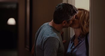Movie still from “Up in the Air” (2009), directed by Jason Reitman – A man and a woman kissing in front of a window; Medium shot, Over the shoulder angle