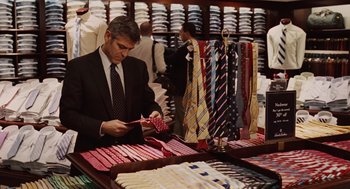 Movie still from “Up in the Air” (2009), directed by Jason Reitman – A man in a suit and tie looking at ties; Medium shot, Over the shoulder angle