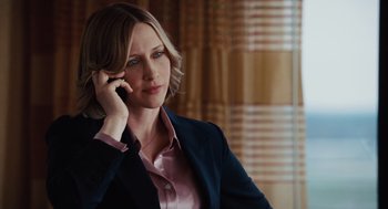 Movie still from “Up in the Air” (2009), directed by Jason Reitman – A woman is talking on a cell phone while wearing a suit; Close Up shot, Over the shoulder angle
