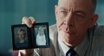 Movie still from “Up in the Air” (2009), directed by Jason Reitman – An older man holding up a picture of a young girl; Close Up shot, Over the shoulder angle