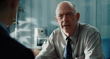 Movie still from “Up in the Air” (2009), directed by Jason Reitman – An older man wearing a plaid shirt and a tie; Close Up shot, Over the shoulder angle