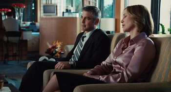 Movie still from “Up in the Air” (2009), directed by Jason Reitman – A man and a woman sitting in a room; Medium shot, Over the shoulder angle