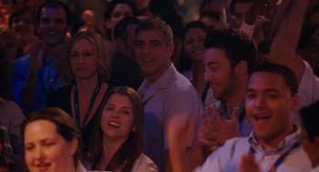 Movie still from “Up in the Air” (2009), directed by Jason Reitman – A group of people sitting in front of an audience; Medium shot, Over the shoulder angle
