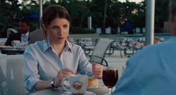 Movie still from “Up in the Air” (2009), directed by Jason Reitman – A woman sitting at an outdoor table with a beverage; Close Up shot, Over the shoulder angle