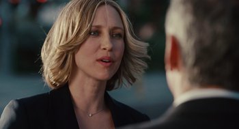 Movie still from “Up in the Air” (2009), directed by Jason Reitman – A person wearing a suit and a necklace; Close Up shot, Over the shoulder angle