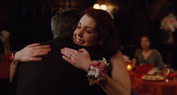 Movie still from “Up in the Air” (2009), directed by Jason Reitman – A man and a woman hugging each other in front of a crowd; Close Up shot, Over the shoulder angle