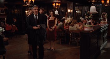 Movie still from “Up in the Air” (2009), directed by Jason Reitman – A group of people standing in a room with tables; Wide shot, Over the shoulder angle