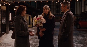 Movie still from “Up in the Air” (2009), directed by Jason Reitman – Two women and a man are standing together; Medium shot, Over the shoulder angle