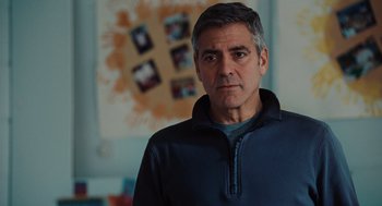 Movie still from “Up in the Air” (2009), directed by Jason Reitman – A man in a blue jacket standing in a room; Close Up shot, Over the shoulder angle