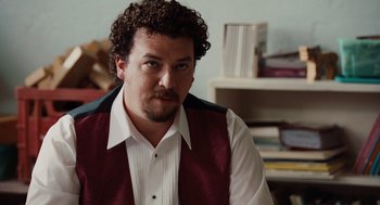 Movie still from “Up in the Air” (2009), directed by Jason Reitman – A person with curly hair wearing a vest; Close Up shot, Over the shoulder angle