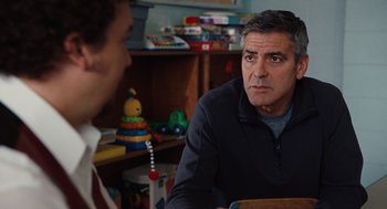 Movie still from “Up in the Air” (2009), directed by Jason Reitman – A man sitting in front of another man in a room; Medium shot, Over the shoulder angle