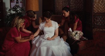 Movie still from “Up in the Air” (2009), directed by Jason Reitman – A woman in a white dress sitting on a couch; Medium shot, High angle