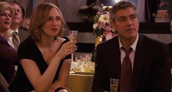 Movie still from “Up in the Air” (2009), directed by Jason Reitman – A man and a woman sitting next to each other at a party; Close Up shot, Over the shoulder angle
