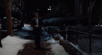 Movie still from “Up in the Air” (2009), directed by Jason Reitman – A man standing on a sidewalk in the snow; Wide shot, Over the shoulder angle