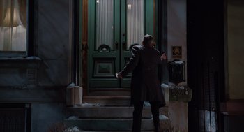 Movie still from “Up in the Air” (2009), directed by Jason Reitman – A man walking down the steps of a door way; Wide shot, Low angle