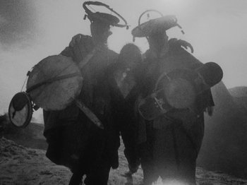 Movie still from “Ankobo + Kaboo - Wakangenei” (2020), directed by Felix Umarov – Medium shot, Low angle