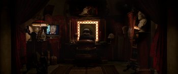 Movie still from “V for Vendetta” (2005), directed by James McTeigue – A man sitting in front of a mirror in front of a television; Wide shot, High angle