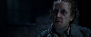 Movie still from “V for Vendetta” (2005), directed by James McTeigue – A person wearing a jacket; Close Up shot, Over the shoulder angle