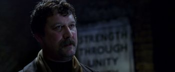 Movie still from “V for Vendetta” (2005), directed by James McTeigue – A person with a mustache; Close Up shot, Low angle