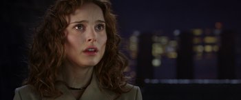 Movie still from “V for Vendetta” (2005), directed by James McTeigue – A person with long curly hair; Close Up shot, Over the shoulder angle