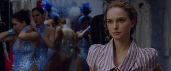 Movie still from “V for Vendetta” (2005), directed by James McTeigue – A woman standing in front of a group of people; Close Up shot, Over the shoulder angle