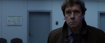 Movie still from “V for Vendetta” (2005), directed by James McTeigue – A person wearing a jacket; Close Up shot, Over the shoulder angle