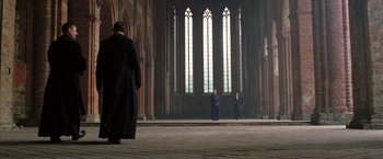 Movie still from “V for Vendetta” (2005), directed by James McTeigue – A group of people standing in front of a large window; Extreme Wide shot, Low angle