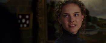 Movie still from “V for Vendetta” (2005), directed by James McTeigue – A person with curly hair; Close Up shot, Over the shoulder angle