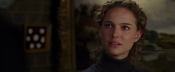 Movie still from “V for Vendetta” (2005), directed by James McTeigue – A person with curly hair; Close Up shot, Over the shoulder angle