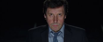 Movie still from “V for Vendetta” (2005), directed by James McTeigue – A person wearing a suit and tie; Close Up shot, Low angle