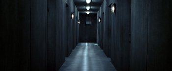Movie still from “V for Vendetta” (2005), directed by James McTeigue – A dark hallway with lights on the walls; Extreme Wide shot, High angle