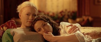 Movie still from “V for Vendetta” (2005), directed by James McTeigue – Two women are laying on a couch together; Close Up shot, Low angle