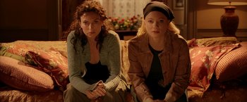Movie still from “V for Vendetta” (2005), directed by James McTeigue – Two women sitting next to each other on a couch; Medium shot, Low angle