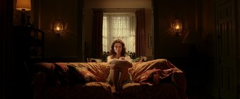 Movie still from “V for Vendetta” (2005), directed by James McTeigue – A woman sitting on top of a couch in front of a window; Wide shot, Low angle