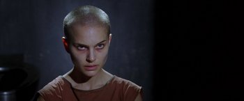 Movie still from “V for Vendetta” (2005), directed by James McTeigue – A woman with a shaved head is looking at the camera; Close Up shot, Low angle