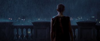 Movie still from “V for Vendetta” (2005), directed by James McTeigue – A woman standing in front of a window in the rain; Wide shot, Over the shoulder angle