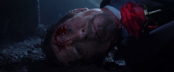 Movie still from “V for Vendetta” (2005), directed by James McTeigue – A man in a suit and tie with a bloody head; Close Up shot, Overhead angle