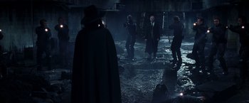 Movie still from “V for Vendetta” (2005), directed by James McTeigue – A group of people in a dark room; Wide shot, Over the shoulder angle