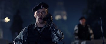 Movie still from “V for Vendetta” (2005), directed by James McTeigue – A man in a military uniform talking on a phone; Close Up shot, Low angle