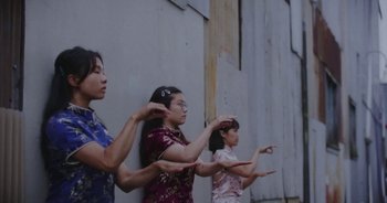 Movie still from “Amanda Sum - Groupthink” (2020), directed by Mayumi Yoshida – Medium shot, Low angle