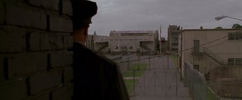 Movie still from “Walk the Line” (2005), directed by James Mangold – A man standing in front of a building with a fence around it; Extreme Wide shot, High angle
