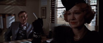 Movie still from “Chinatown” (1974), directed by Roman Polanski – An older woman holding a cigarette in her hand; Close Up shot, Low angle