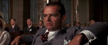 Movie still from “Chinatown” (1974), directed by Roman Polanski – A man in a suit and a tie; Close Up shot, Low angle