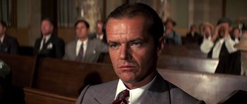 Movie still from “Chinatown” (1974), directed by Roman Polanski – A man in a suit and tie in a court room; Close Up shot, Low angle